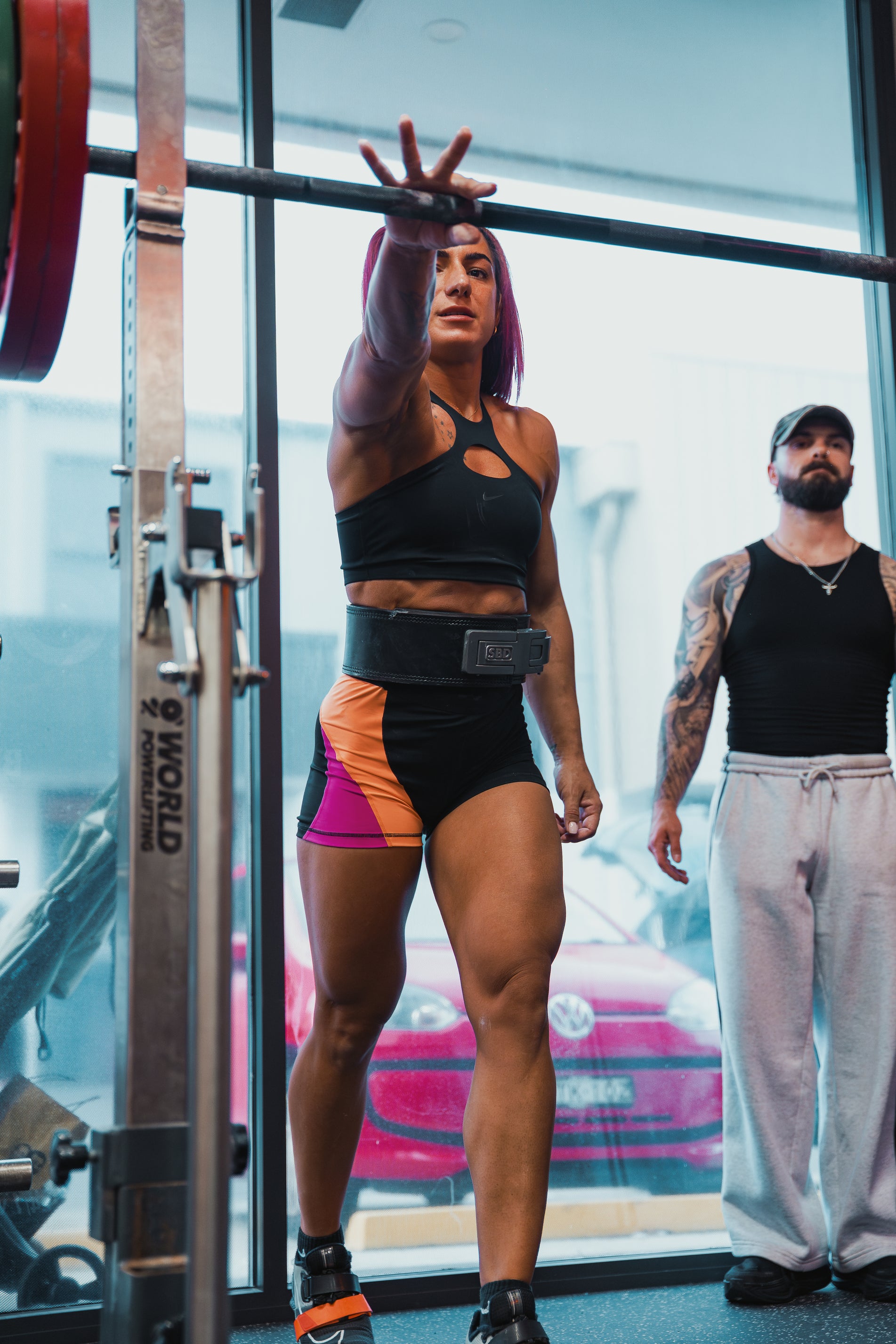 Woman lifting weights with a personal trainer in a gym setting
